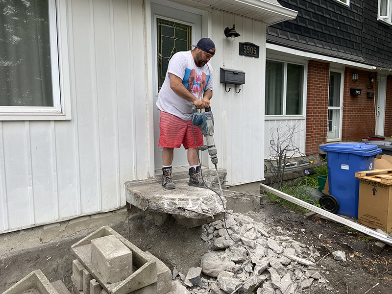 Travaux de reconstruction de balcon dentree residentielle - Démolition de béton, construction de coffrage pour balcon, installation de pieux renforts, coule et finition de béton