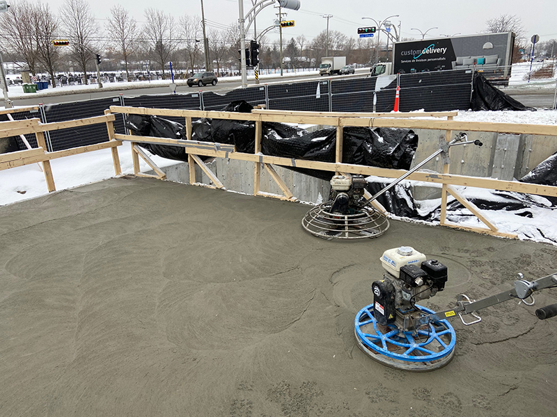 Construction dalle de beton structurale à Montréal, Pointe-Claire - Mise en place du béton, finition du béton à la truelle mécanique (finition de béton à la machine, polie, lustré) à Pointe-Claire