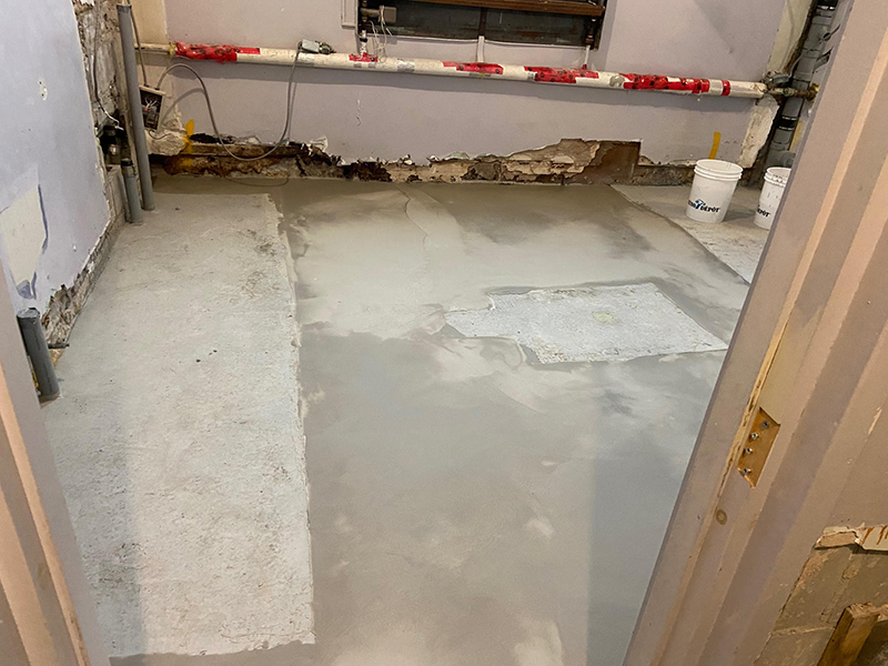 Projet de beton auto nivelant dans un batiment institutionnel - Installation de la colle à base d’epoxy, mise en place, coule et finition du béton auto nivelant. Travaux effectués a Chambly
