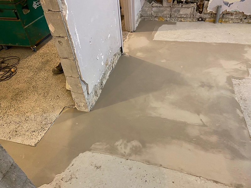 Projet de beton auto nivelant dans un batiment institutionnel - Installation de la colle à base d’epoxy, mise en place, coule et finition du béton auto nivelant. Travaux effectués a Chambly