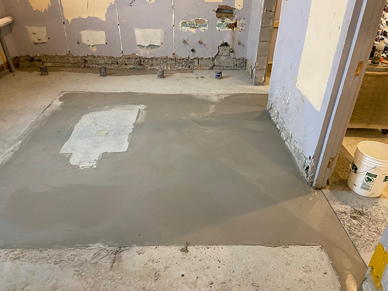 Projet de beton auto nivelant dans un batiment institutionnel - Installation de la colle à base d’epoxy, mise en place, coule et finition du béton auto nivelant. Travaux effectués a Chambly