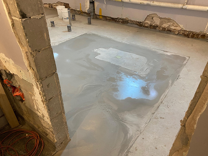 Projet de beton auto nivelant dans un batiment institutionnel - Installation de la colle à base d’epoxy, mise en place, coule et finition du béton auto nivelant. Travaux effectués a Chambly