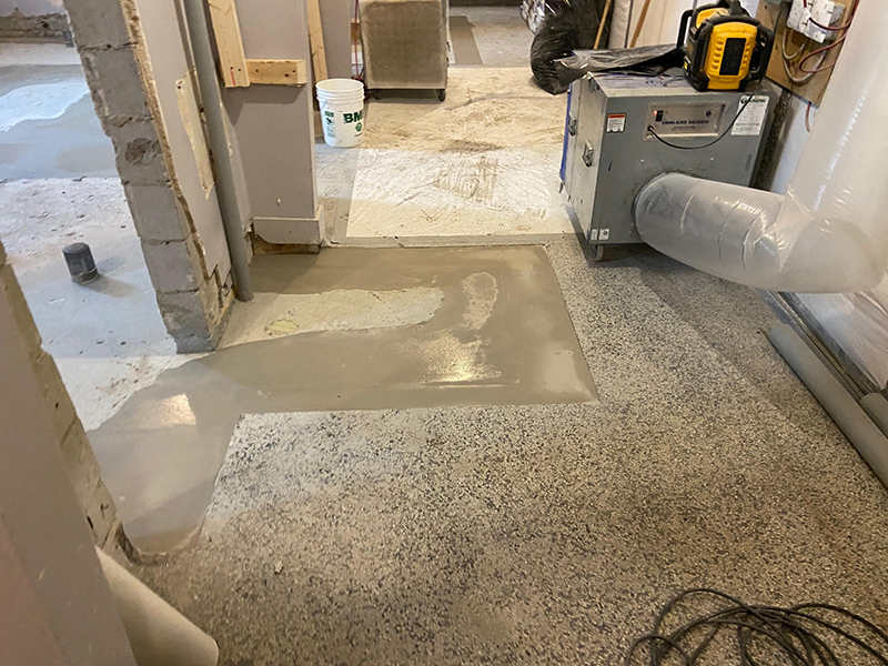 Projet de beton auto nivelant dans un batiment institutionnel - Installation de la colle à base d’epoxy, mise en place, coule et finition du béton auto nivelant. Travaux effectués a Chambly
