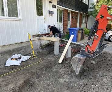 Travaux de reconstruction de balcon dentree residentielle partie 1 - Démolition de béton, construction de coffrage pour balcon, installation de pieux renforts, coule et finition de béton
