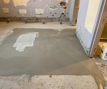 Projet de beton auto nivelant dans un batiment institutionnel - Installation de la colle à base d’epoxy, mise en place, coule et finition du béton auto nivelant. Travaux effectués a Chambly